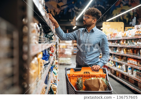 Taking the product. Man is in the grocery store Taking the product. Man is in the grocery store 136757605