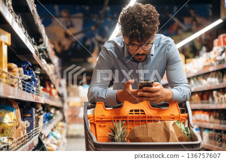 Customer is with phone. Man is in the grocery store 136757607