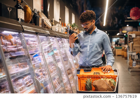 Bottle in hand. Man is in the grocery store Bottle in hand. Man is in the grocery store 136757619