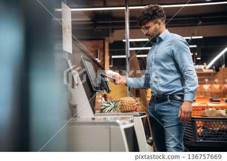 By cash register. Man is in the grocery store By cash register. Man is in the grocery store 136757669