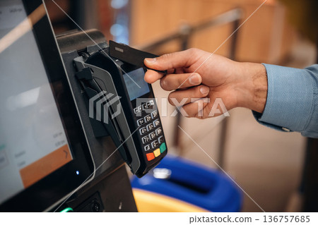 Wireless transfer. Close up view of man customer that is paying for products by credit card in grocery store 136757685