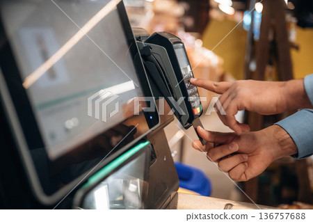 Wireless transfer. Close up view of man customer that is paying for products by credit card in grocery store 136757688