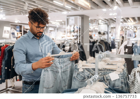 Man customer is in the clothing store Man customer is in the clothing store 136757733