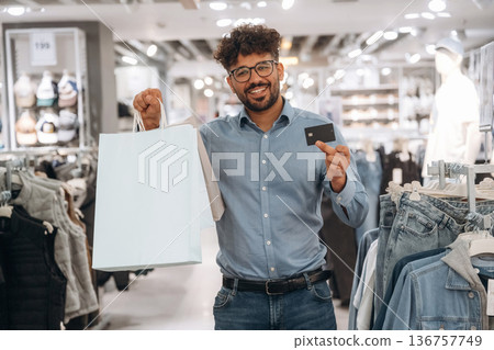 Payment by credit card. Man customer is in the clothing store Payment by credit card. Man customer is in the clothing store 136757749
