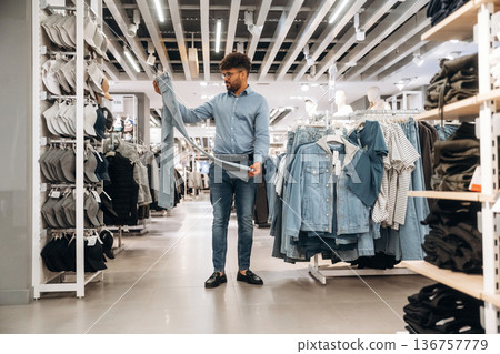 Looking and choosing. Man customer is in the clothing store 136757779