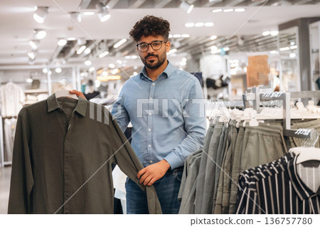Man customer is in the clothing store Man customer is in the clothing store 136757780