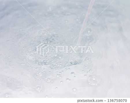 Serene water scene. Soft lighting highlights smooth ceramic surface with floating bubbles 136758070