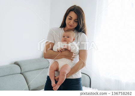 In domestic room, standing. Woman is with her little toddler baby daughter 136758262