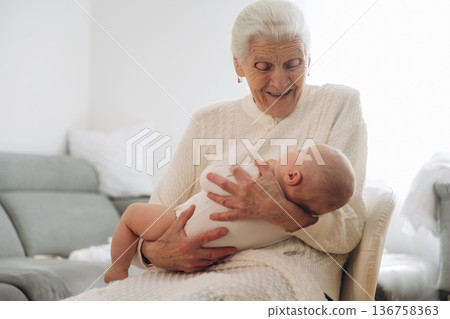 Smiling, enjoying. Grandmother with cute toddler baby at home Smiling, enjoying. Grandmother with cute toddler baby at home 136758363