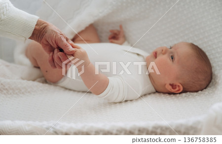 Senior woman is holding hands with little baby Senior woman is holding hands with little baby 136758385