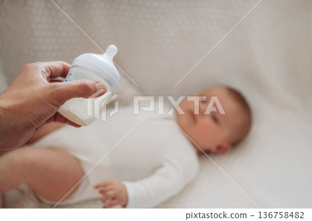 Giving bottle. Close up view of mother and little baby Giving bottle. Close up view of mother and little baby 136758482