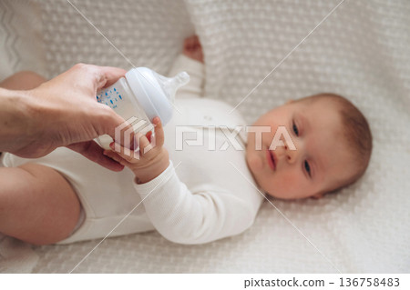 Giving bottle. Close up view of mother and little baby Giving bottle. Close up view of mother and little baby 136758483