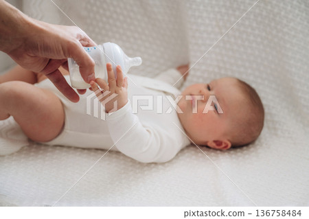 Giving bottle. Close up view of mother and little baby Giving bottle. Close up view of mother and little baby 136758484