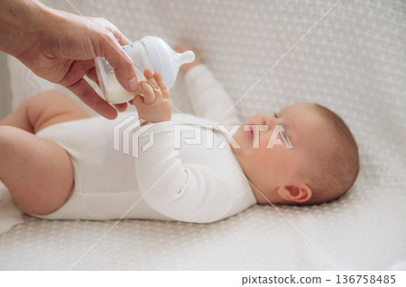Giving bottle. Close up view of mother and little baby Giving bottle. Close up view of mother and little baby 136758485