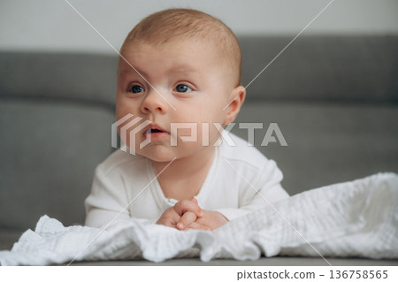 Lying down. Cute little baby is on the sofa Lying down. Cute little baby is on the sofa 136758565