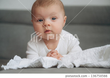 Lying down. Cute little baby is on the sofa Lying down. Cute little baby is on the sofa 136758566