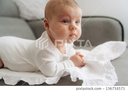 On the sofa. Cute little baby is lying down On the sofa. Cute little baby is lying down 136758571