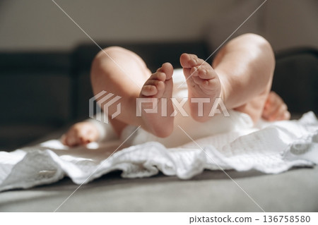 Baby is lying down on the towel, view of the legs 136758580