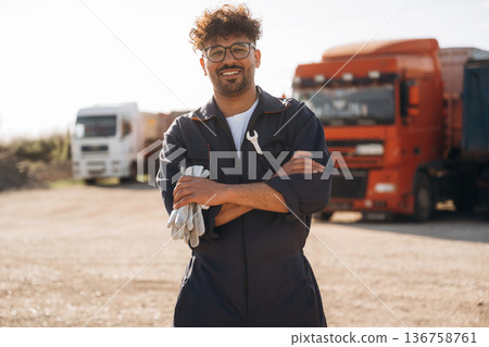 Smiling, positive facial expression. Male worker is near truck outdoors Smiling, positive facial expression. Male worker is near truck outdoors 136758761