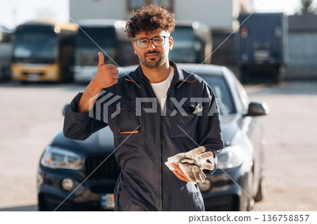 Work is done. Mechanic is with the car outdoors Work is done. Mechanic is with the car outdoors 136758857