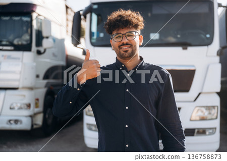 Front view. Male worker is near truck outdoors 136758873