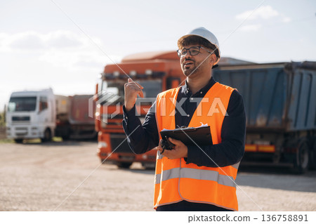 Male worker is near truck outdoors Male worker is near truck outdoors 136758891
