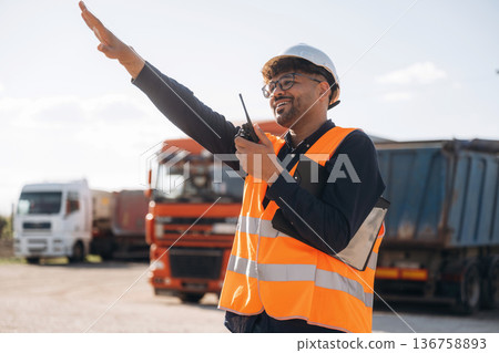 Gestures with hands. Male worker is near truck outdoors 136758893