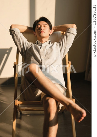 A man relaxing in the sunshine on a sunny afternoon 136759133