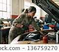 Female mechanic facing the engine 136759270