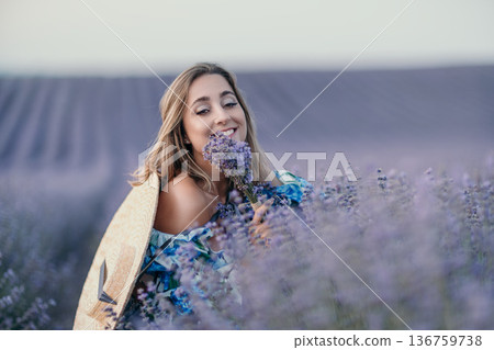 Woman lavender field smiling while smelling a bouquet in a blooming purple meadow during sunset with copy space Woman lavender field smiling while smelling a bouquet in a blooming purple meadow during sunset with copy space 136759738