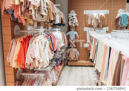 Inside the kid's clothing store. Shirts and sweaters are hanging Inside the kid's clothing store. Shirts and sweaters are hanging 136759841