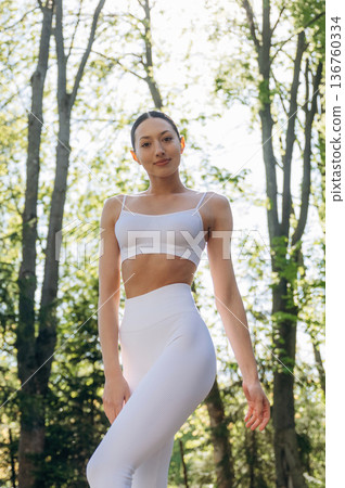 Standing in the forest. Beautiful fitness yoga woman is outdoors, amazing nature Standing in the forest. Beautiful fitness yoga woman is outdoors, amazing nature 136760334