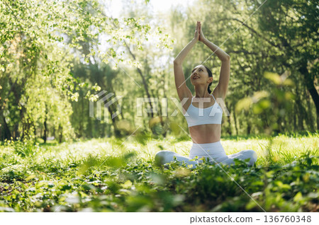 Sitting on the grass. Beautiful fitness yoga woman is outdoors, amazing nature Sitting on the grass. Beautiful fitness yoga woman is outdoors, amazing nature 136760348