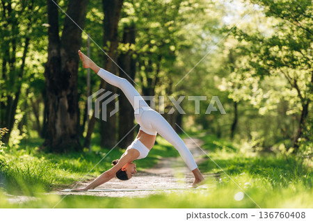Exercises for flexibility. Beautiful fitness yoga woman is outdoors, amazing nature 136760408