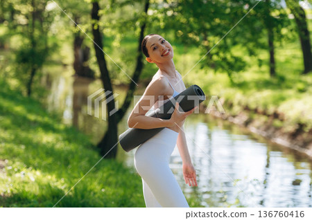 Near the river. Beautiful fitness yoga woman is outdoors, amazing nature Near the river. Beautiful fitness yoga woman is outdoors, amazing nature 136760416