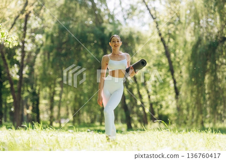 Smiling, positive facial expression. Beautiful fitness yoga woman is outdoors, amazing nature Smiling, positive facial expression. Beautiful fitness yoga woman is outdoors, amazing nature 136760417