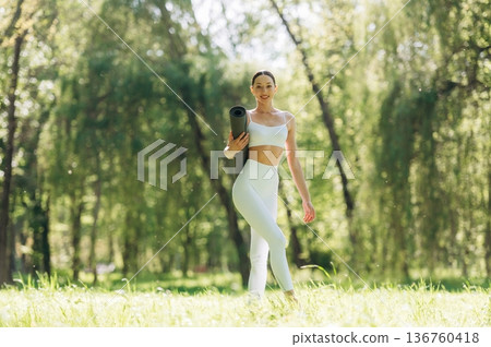 Smiling, positive facial expression. Beautiful fitness yoga woman is outdoors, amazing nature Smiling, positive facial expression. Beautiful fitness yoga woman is outdoors, amazing nature 136760418