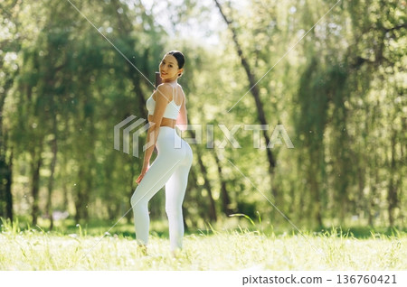 Smiling, positive facial expression. Beautiful fitness yoga woman is outdoors, amazing nature 136760421