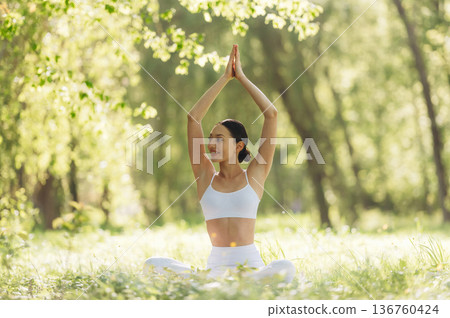 On the grass, sitting. Beautiful fitness yoga woman is outdoors, amazing nature On the grass, sitting. Beautiful fitness yoga woman is outdoors, amazing nature 136760424