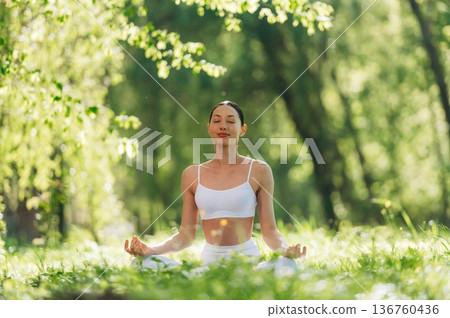 Lotus pose, sitting on the grass. Beautiful fitness yoga woman is outdoors, amazing nature Lotus pose, sitting on the grass. Beautiful fitness yoga woman is outdoors, amazing nature 136760436