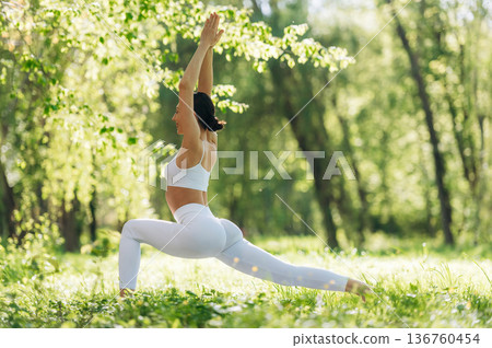 Spine stretching. Beautiful fitness yoga woman is outdoors, amazing nature Spine stretching. Beautiful fitness yoga woman is outdoors, amazing nature 136760454