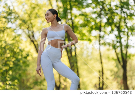 Against trees, standing. Beautiful fitness yoga woman is outdoors, amazing nature Against trees, standing. Beautiful fitness yoga woman is outdoors, amazing nature 136760548