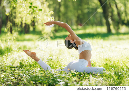 Spine stretching. Beautiful fitness yoga woman is outdoors, amazing nature 136760653