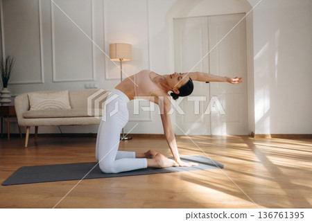 Modern interior, on the floor. Young woman in fitness clothes is in the room Modern interior, on the floor. Young woman in fitness clothes is in the room 136761395