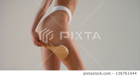 Cleaning the skin with brush. Close up view of woman that is in fitness clothes 136761444