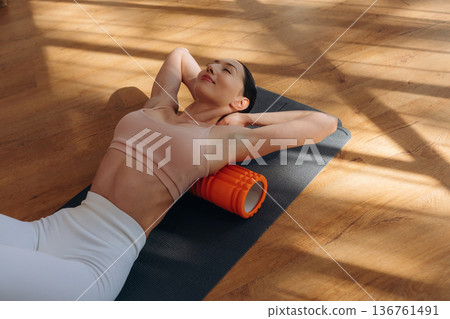 Top view. Woman is doing abs on the yoga mat at home Top view. Woman is doing abs on the yoga mat at home 136761491