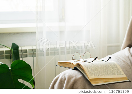Book and glasses resting on a cozy blanket Book and glasses resting on a cozy blanket 136761599