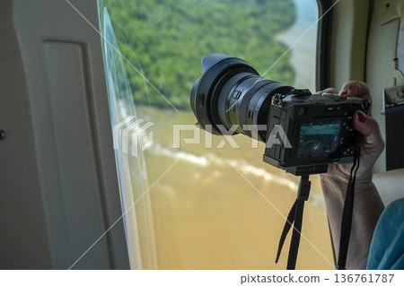 A photographer taking a photo Aerial view Iguazu falls waterfalls Scenic destination panorama from helicopter tour A photographer taking a photo Aerial view Iguazu falls waterfalls Scenic destination panorama from helicopter tour 136761787