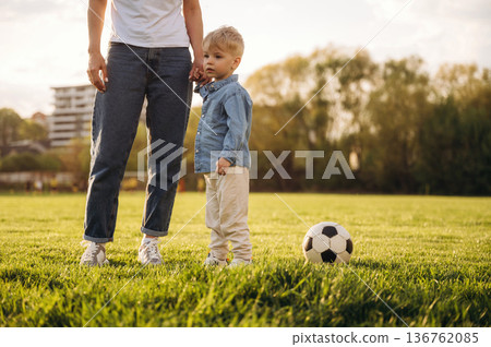 Warm sunlight. Mother and son are together on the summer field Warm sunlight. Mother and son are together on the summer field 136762085