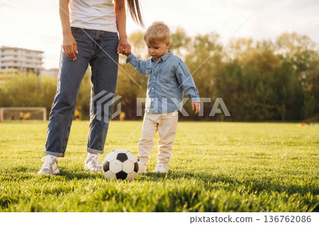 Warm sunlight. Mother and son are together on the summer field Warm sunlight. Mother and son are together on the summer field 136762086